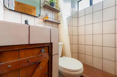 a bathroom with a toilet and a sink and a mirror at The Red Door Mountain Cabin in Guadalupe