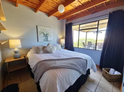 a bedroom with a bed and a large window at The Red Door Mountain Cabin in Guadalupe