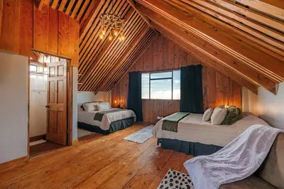 a bedroom with two beds in a room with wooden ceilings at The Red Door Mountain Cabin in Guadalupe