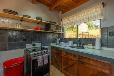 a kitchen with a stove and a sink and a window at The Red Door Mountain Cabin in Guadalupe