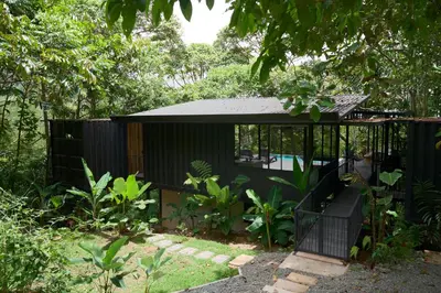 a small black house with a black roof at Casa Alba - Portasol Vacation in Savegre