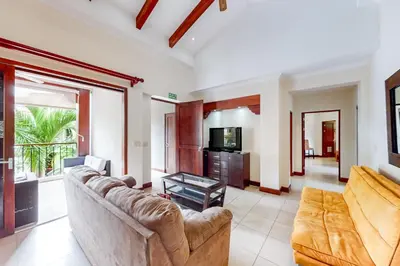 a living room with a couch and a tv at Macaw Oceans Club#20 in Jacó