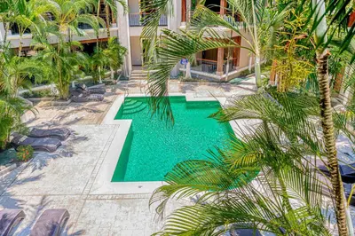 an overhead view of a swimming pool with palm trees at Macaw Oceans Club#20 in Jacó