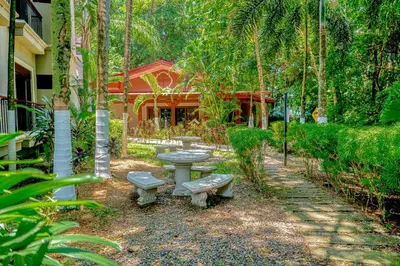 a picnic table and benches in front of a house at Macaw Oceans Club#20 in Jacó