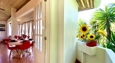 a dining room with a table and sunflowers on the wall at Cottage in Magic Mountain Views in Barrio Jesús