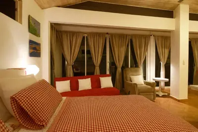 a bedroom with a bed and a couch and a chair at Cottage in Magic Mountain Views in Barrio Jesús